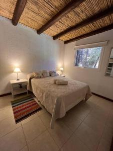 a bedroom with a large bed and a window at Cabaña Chacras de Caro in Chacras de Coria