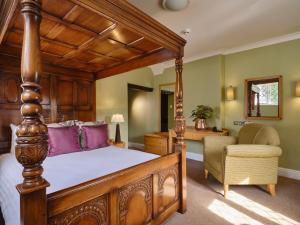 a bedroom with a canopy bed and a chair at The Kingfisher in Bedford