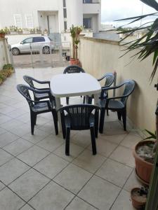 einen weißen Tisch und Stühle auf einer Terrasse in der Unterkunft Casa Vacanze Manin in Casamassella