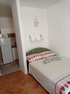 Un dormitorio pequeño con una cama y un refrigerador. en Alina centar, en Novigrad Istria
