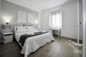 a white bedroom with a large bed and a window at Guest House Romano in Rome