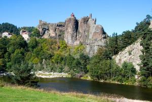 rzeka z dużą formacją skalną obok góry w obiekcie Maison de charme en campagne à Arlempdes avec jardin w mieście Arlempdes