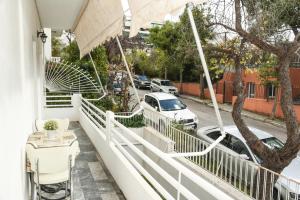 a balcony of a house with cars parked on the street at Sunny and Quiet 1 Bedroom Apt in Athens