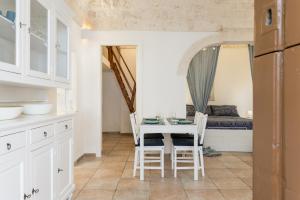 een keuken en eetkamer met een tafel en stoelen bij Cozy Historic Home by Wonderful Italy in Ostuni