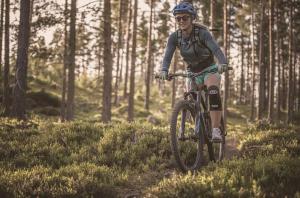 a person riding a bike on a trail in the woods at Nedre Amla Fjord Apartment in Kaupanger