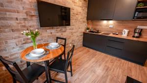 a kitchen with a wooden table with chairs and a counter at Centrum Cicha, Sun & Snow in Krynica Zdrój +7 photos