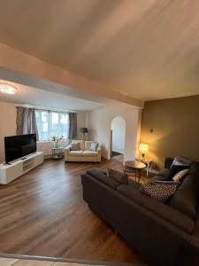 sala de estar con sofá y TV en Edge of Glastonbury and Street Town Centre, Ground Floor Large 3 BD With Parking, en Street