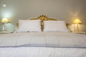 a bed with two white pillows and two lamps at Le Boulevard in Corfu Town +24 photos
