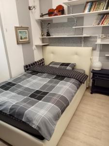 1 cama con edredón blanco y negro en una habitación en AURY HOUSE - STATlON - -ViaDante-Platani- en Cremona