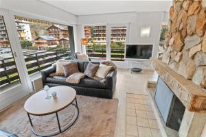 a living room with a couch and a fireplace at Joli appartement en plein centre in Nendaz