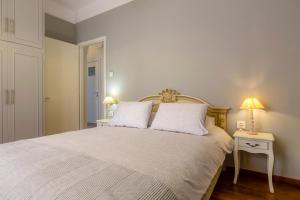 a bedroom with a bed with two lamps on a table at Le Boulevard in Corfu
