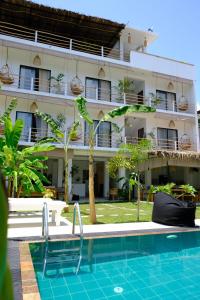 a hotel with a swimming pool in front of a building at OASIA - Boutique Surf House (ADULTS ONLY) in Weligama