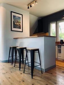 a bar in a kitchen with four stools at Le Petit Bourdieu - Sanglier in Jurançon