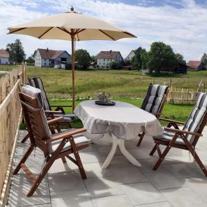 uma mesa e cadeiras com um guarda-sol num pátio em Wolke 7 em Görwihl