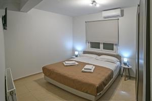 a bedroom with a bed with two towels on it at A & G Apartments in Kolymvari