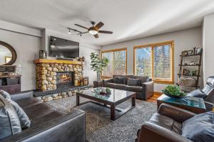 a living room with couches and a fireplace at Spring Creek Condo by Canadian Rockies Vacation Rentals in Canmore