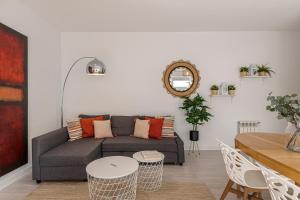 a living room with a couch and a table at BNBHolder Terrace, Pool & Gym LAS TABLAS in Madrid