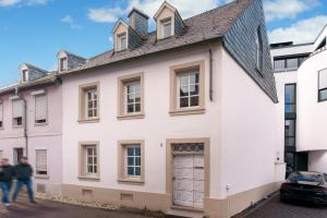 uma casa branca com uma porta cinzenta em Casa Benedicta em Trier