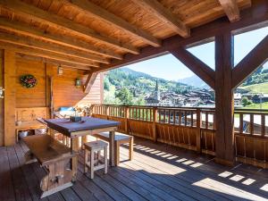 a large wooden deck with a table and bench on it at Appartement La Clusaz, 4 pièces, 7 personnes - FR-1-437-45 in La Clusaz