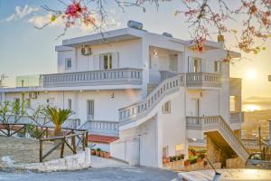 Una gran casa blanca con escaleras. en A & G Apartments, en Kolimvárion