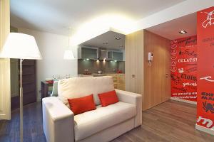 a living room with a white couch with two red pillows at Ola Living Portaferrissa in Barcelona