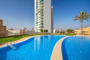 duży niebieski basen obok wysokiego budynku w obiekcie Skyline 6 Private balcony, sunny all year round, with nice views w mieście Benidorm