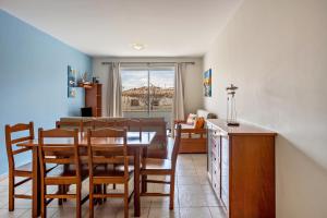 a kitchen and dining room with a table and chairs at Sonho Dourado Apartamento de praia in Porto Santo