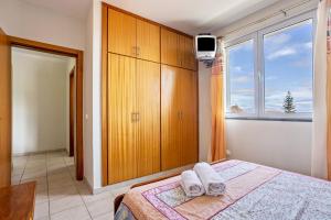 um quarto com uma cama e uma grande janela em Sonho Dourado Apartamento de praia em Porto Santo