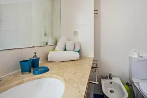 a bathroom with a sink and a toilet and a mirror at Sonho Dourado Apartamento de praia in Porto Santo +13 photos