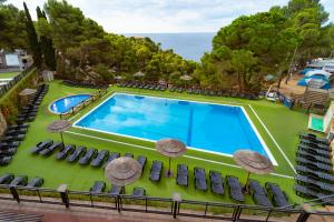 an image of a swimming pool with chairs and umbrellas at Kampaoh Tossa de Mar in Tossa de Mar