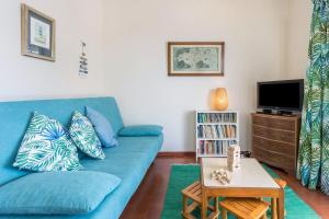 a living room with a blue couch and a tv at Formosa Beach in Porto Santo