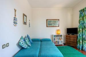 a bedroom with a blue bed and a tv at Formosa Beach in Porto Santo