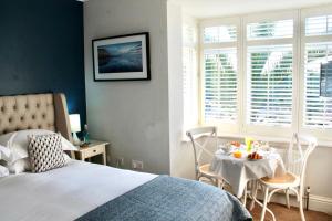 a bedroom with a bed and a table with food on it at The Bosham Boathouse in Chichester