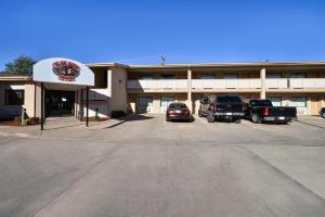a building with cars parked in a parking lot at Budget Inn & Suites Guymon in Guymon