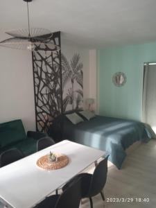 a bedroom with a bed and a table with chairs at Studio plein centre face au lac in Bagnoles de l'Orne