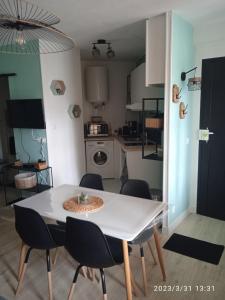 a table and chairs in a room with a kitchen at Studio plein centre face au lac in Bagnoles de l'Orne