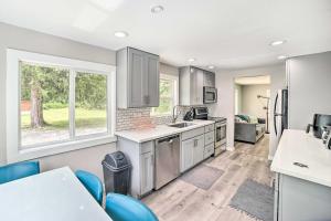 a kitchen with white cabinets and blue chairs at Modern Gold Bar Vacation Rental with Mountain View in Gold Bar