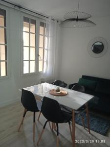 salon ze stołem i krzesłami w obiekcie Studio plein centre face au lac, cave vélo w mieście Bagnoles de l'Orne +8 zdjęć