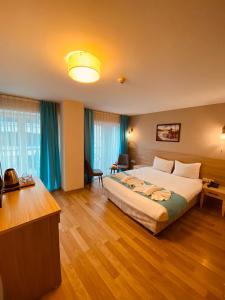 Habitación de hotel con cama grande y escritorio. en Asteria Hotel Sirkeci en Estambul