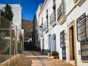 an alley in a town with white buildings at El Nido Alojamiento Turístico in Níjar