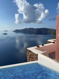 a swimming pool with a view of a body of water at Nano Oia Canaves in Oia