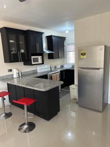 a kitchen with black cabinets and a stainless steel refrigerator at Mandeville ingleside luxury in Mandeville