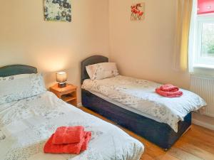 Dos camas en una habitación con toallas rojas. en Primrose - W43303 en Goxhill