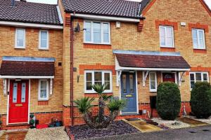 a brick house with red and blue doors at Luxury 2 Bedroom House with Garden & Free Parking in West Thurrock