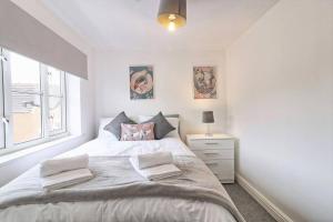 Un dormitorio blanco con una cama grande y una ventana en Luxury 2 Bedroom House with Garden & Free Parking, en West Thurrock