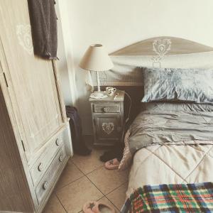 1 dormitorio con 1 cama y 1 mesa con lámpara en B&B Il moro selvatico, en Poviglio
