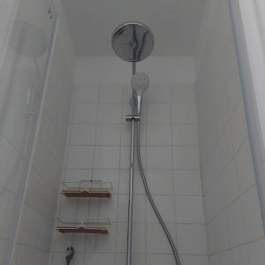 een douche met een douchekop in de badkamer bij Suit'home in Fort-Mahon-Plage