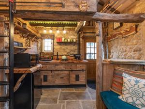 a kitchen in a cabin with wooden walls at Woolcombers in Addingham