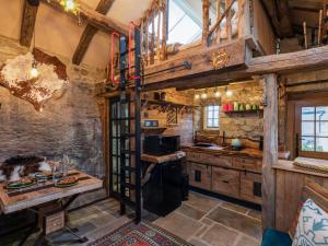 a kitchen with wooden walls and a spiral staircase in a log cabin at Woolcombers in Addingham