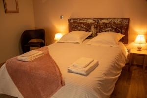 ein Schlafzimmer mit einem großen weißen Bett mit Handtüchern darauf in der Unterkunft Le Triplex - 4 pers - Wifi - Centre ville in Mende